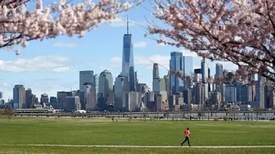 a person walking in a park with a view of a city at 2 Living Rooms - King bd - Deck - BBQ - Airport 15 min in Bayonne