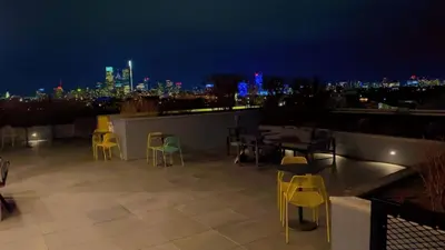 a rooftop patio with tables and chairs at night at StudioAprt QueenBed,WiFi,WD,Parking,Gym in Philadelphia