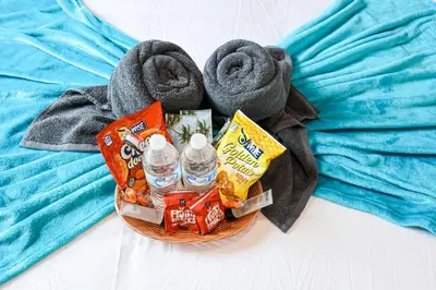 a basket with bottled water and towels on a bed at StudioAprt QueenBed,WiFi,WD,Parking,Gym in Philadelphia