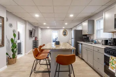 a kitchen with a table and chairs in a room at Updated 3BR 2BA Apartment Near NYC Airport in Bayonne