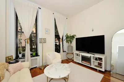 a white living room with a tv and a couch at Prime Murray Hill 1BR - Near Grand Central in New York