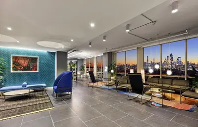 a lobby with tables and chairs and a view of the city at Ultra Luxury Apt - Panoramic NYC View - Minutes to City in Hoboken