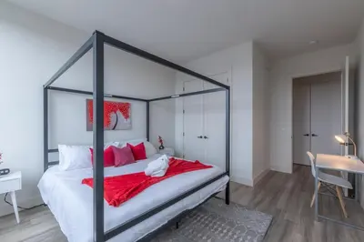 a bedroom with a black canopy bed with red pillows at Stylish Apt FREE Parking Near NYC & Airport in East Orange