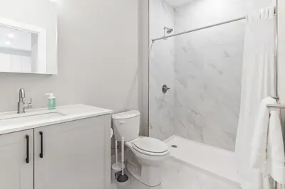 a white bathroom with a toilet and a shower at 10 mins to CenterCity, With Queen Bed, Views from RT! in Philadelphia