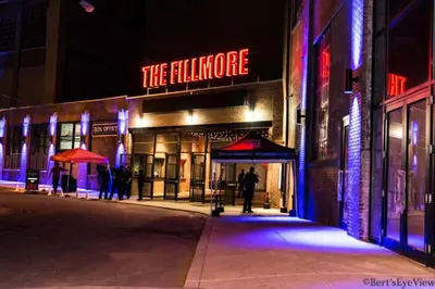 a man standing in front of a building with a neon sign at 5 mins to Fillmore! Queen Bed, Rooftop, NorthernLibs! in Philadelphia