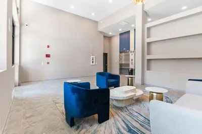 a living room with blue chairs and a table at 5 mins to Fillmore! Queen Bed, Rooftop, NorthernLibs! in Philadelphia