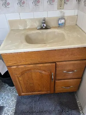 a sink in a bathroom with a wooden cabinet at Amazing House near EWR and NYC in Linden