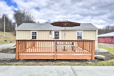 a house with an umbrella on a wooden deck at Farm Stay Close to Ski Adventures in Pleasant Mount