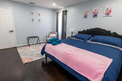 a bedroom with a large bed with blue and pink sheets at Cozy Apt Lake Park Station Airport Hospital NJ NYC in Rahway