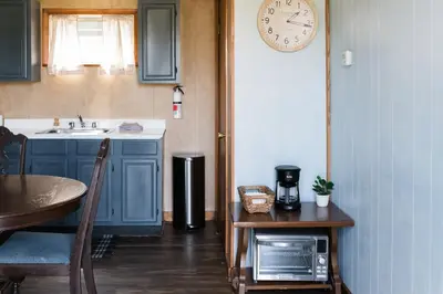 a kitchen with a table and a clock on the wall at Beaver Creek Cabin 6 in Strasburg