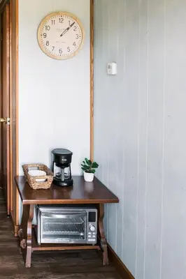 a microwave on a table with a clock on the wall at Beaver Creek Cabin 6 in Strasburg