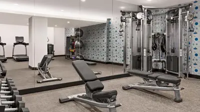 a gym with several tread machines and mirrors at The Vibe on 5th Vibe 8750 in New York