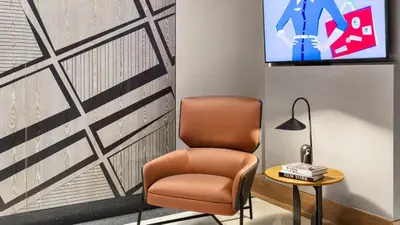 a room with a chair and a tv on a wall at The Vibe on 5th IV Vibe 8753 in New York