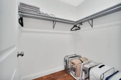 a shelf in a room with luggage and towels at Home away from home 2 in Newark
