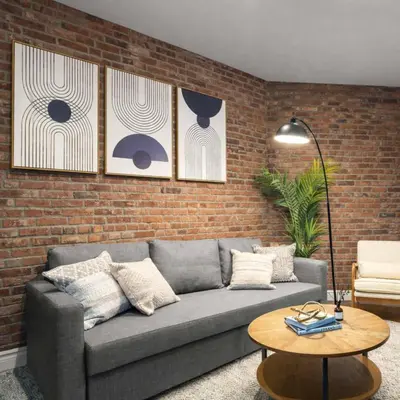 a living room with a couch and a brick wall at Modern Manhattan Haven Near Everything in New York