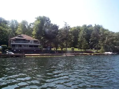 a large lake with a large building in the background at Cozy Rustic Cabin Rental on Shore of Harveys Lake in Luzerne County, Pennsylvania in Harveys Lake