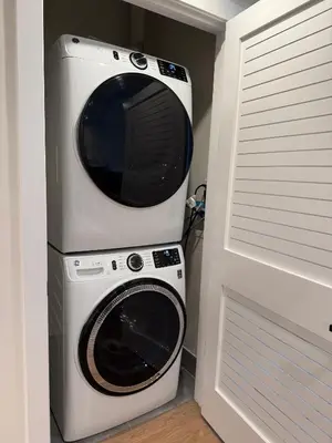 a microwave and a washing machine in a room at Sunny 2BR Loft • Work Relax Minutes to NYC in Hoboken
