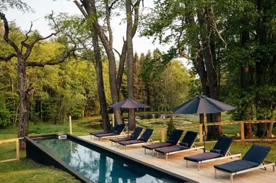 a group of chairs and umbrellas next to a pool at The Rest Suite 5 in Kenoza Lake