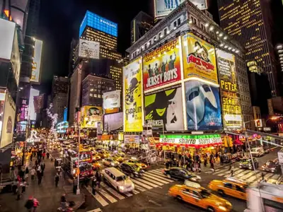 a busy city street at night with cars and taxis at Adventures In NYC Only 10 Mins to NYC in Union City