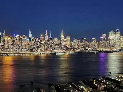 a view of a city at night with the water at Sweet Diamonds & Adventures 10 Mins To NYC in Union City