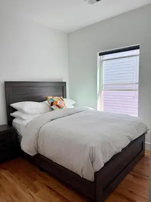 a bedroom with a large bed and a window at Cozy 3BR Retreat with Rooftop Near EWR & NYC Access in Newark