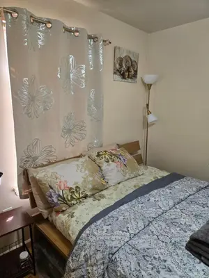 a bedroom with a bed and a curtain with flowers at Joy queen room 6A in Newark