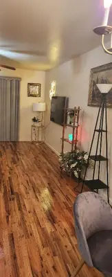 a living room with wooden floors and a flat screen tv at Joy queen room 6A in Newark
