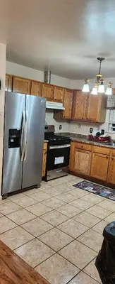 a kitchen with a stainless steel refrigerator and wooden cabinets at Joy queen room 6A in Newark