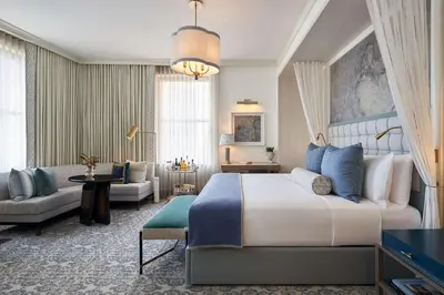 a bedroom with a large bed and a living room at The Wall Street Hotel by Suiteness in New York