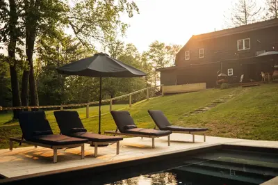 a group of chairs and an umbrella next to a pool at Coop 003 in Kenoza Lake