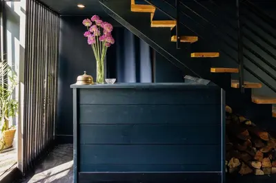 a vase of pink flowers on a table next to a staircase at Coop 004 in Kenoza Lake