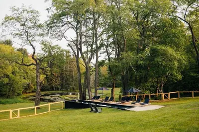 a group of chairs sitting on a dock in the grass at Suite 001 in Kenoza Lake