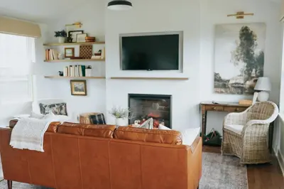 a living room with a brown leather couch and a fireplace at Luxury Cabin at Beaver Creek with hot tub and stunning views in Strasburg