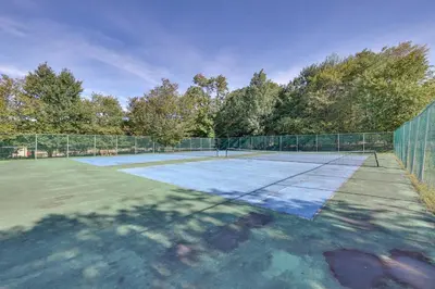 a tennis court with a net on top of it at Poconos Family Home with Lake Access and Game Room in Tobyhanna