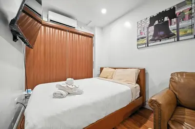 a small bedroom with a bed and a chair at Cozy Modern Studio Perfect for Short or Long Stays in Philadelphia