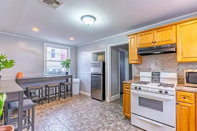 a kitchen with wooden cabinets and a white stove top oven at Private BR Trains EWR USA Mall Penn Station in Newark