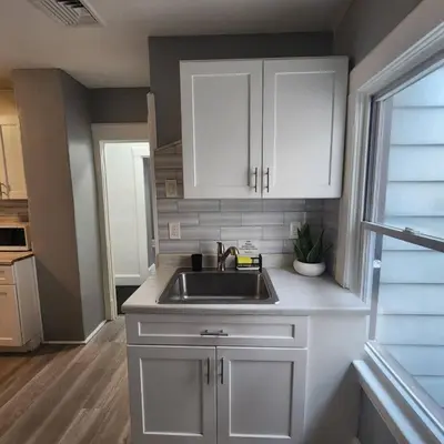 a kitchen with white cabinets and a sink at Private Bedroom w Shared Space A in South Hackensack