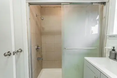 a shower with a glass door in a bathroom at Bunk Room Walk 2 Train Shops in Bayonne