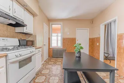 a kitchen with white appliances and a black table at Roomy 4br Walk to Transit connect to NYC in Bayonne