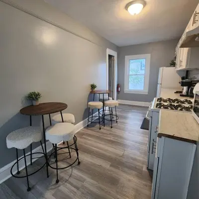 a kitchen with four bar stools and a counter at Private Bedroom In Shared Apt B in South Hackensack