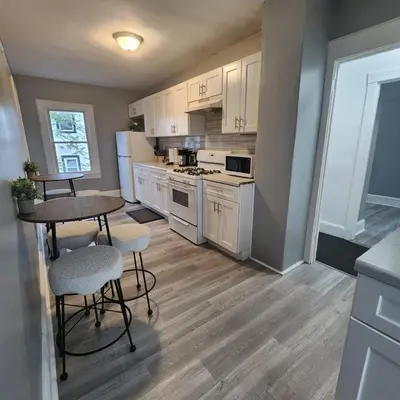 a kitchen with white appliances and a table and chairs at Private Bedroom In Shared Apt B in South Hackensack