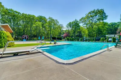 a swimming pool with blue water and trees at Home with Fire Pit in Jim Thorpe 6 Mi to Dtwn! in Jim Thorpe