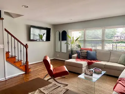 a living room with a couch and a table at Easy PATH&Bus access- NYC designer home & Terrace in Jersey City