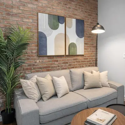 a couch in a living room with a brick wall at Stylish Retreat in Prime West Village Spot in New York