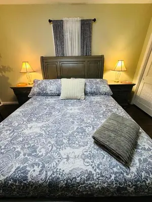 a bedroom with a blue and white bed with two lamps at The Trenton Two 2BR Peaceful Oasis with Patio - Shared Home in Trenton