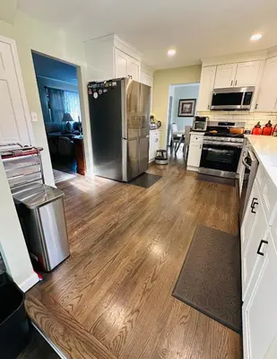 a kitchen with a stainless steel refrigerator and wooden floors at The Trenton Two 2BR Peaceful Oasis with Patio - Shared Home in Trenton