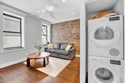 a living room with a washing machine and a couch at Stylish 3BR-2BA in Gramercy -Modern & Central in New York