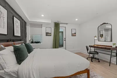 a bedroom with a large bed and a desk at SLEEP 8 Outdoor Patio-Old City- 2 NEW Townhouses in Philadelphia