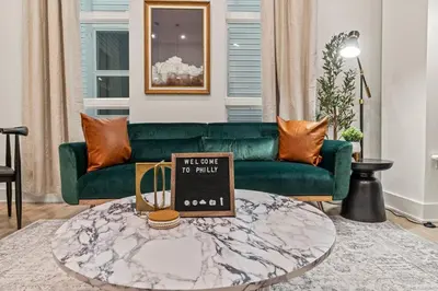 a living room with a green couch and a coffee table at Townhouse SLEEP 4 Walk to Liberty Bell |Old City in Philadelphia