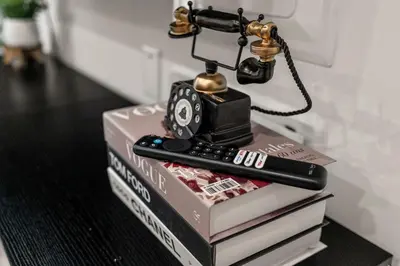 a telephone on top of books with a remote control at Sleep 3- Beautiful Unit- Walk Around in Old City in Philadelphia